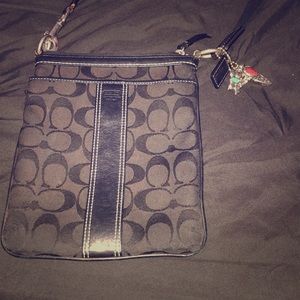 Coach purse with charms on the strap .